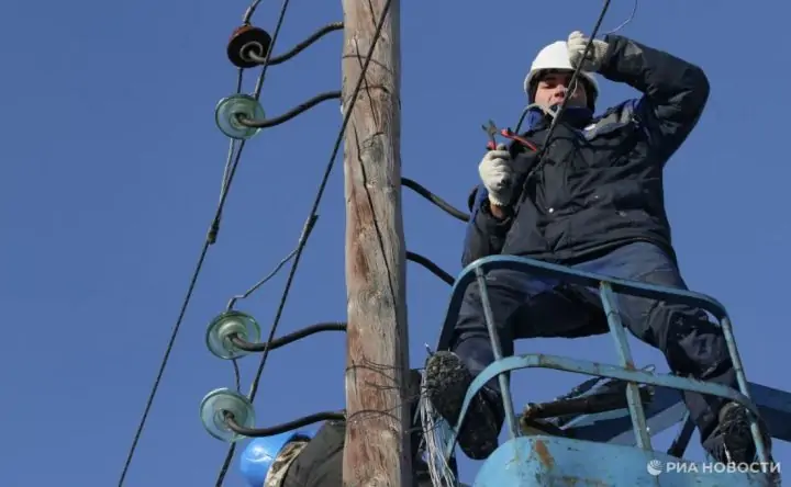 Электрик на опоре линии электропередачи. Фото РИА Новости, Алексея Мальгавко